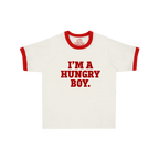 A white ringer t-shirt with red trim on the collar and sleeve cuffs, featuring the text 'I'M A HUNGRY BOY.' printed in red across the chest.